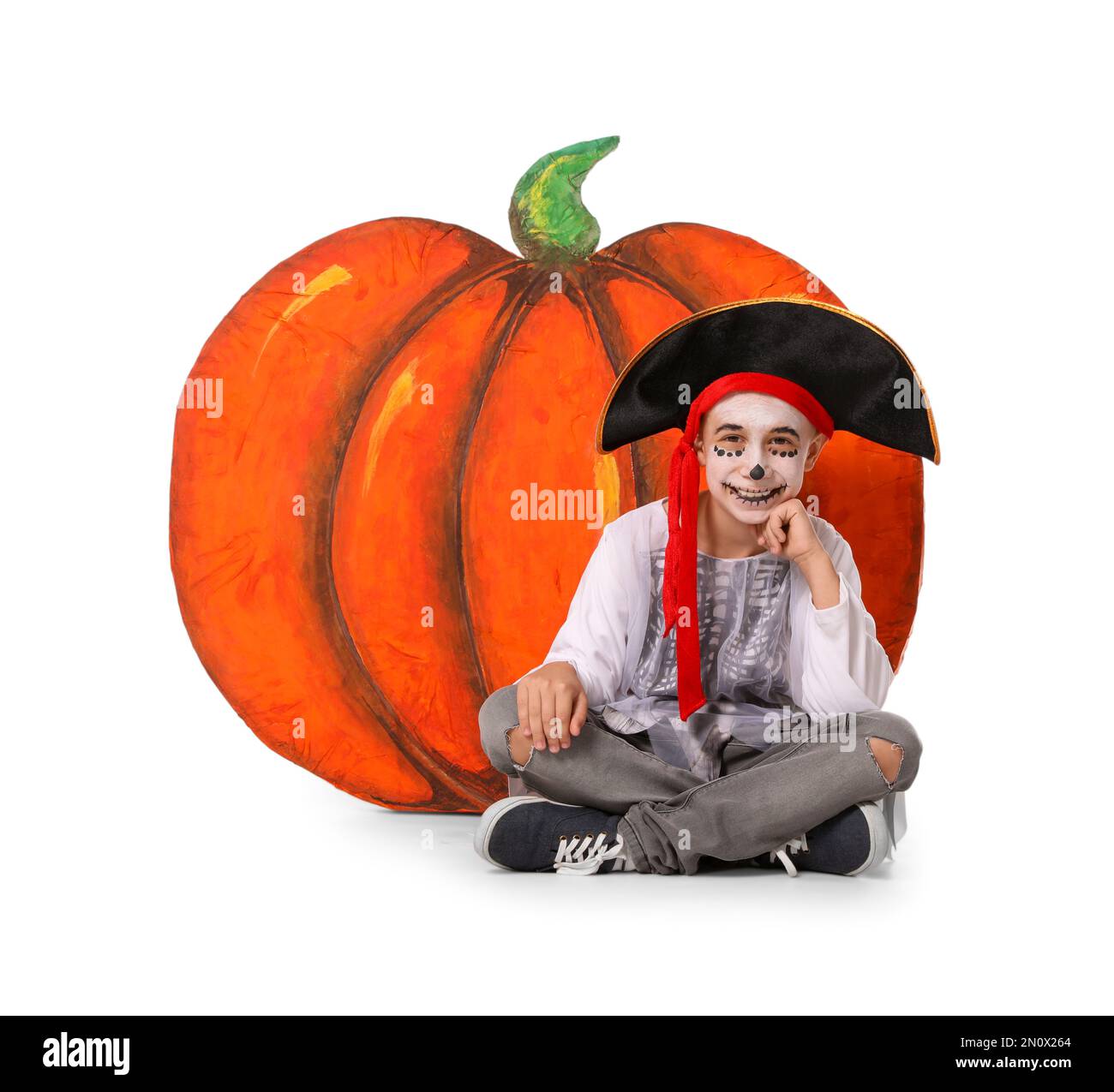 Joli petit garçon portant un costume d'Halloween et une citrouille décorative sur fond blanc Banque D'Images