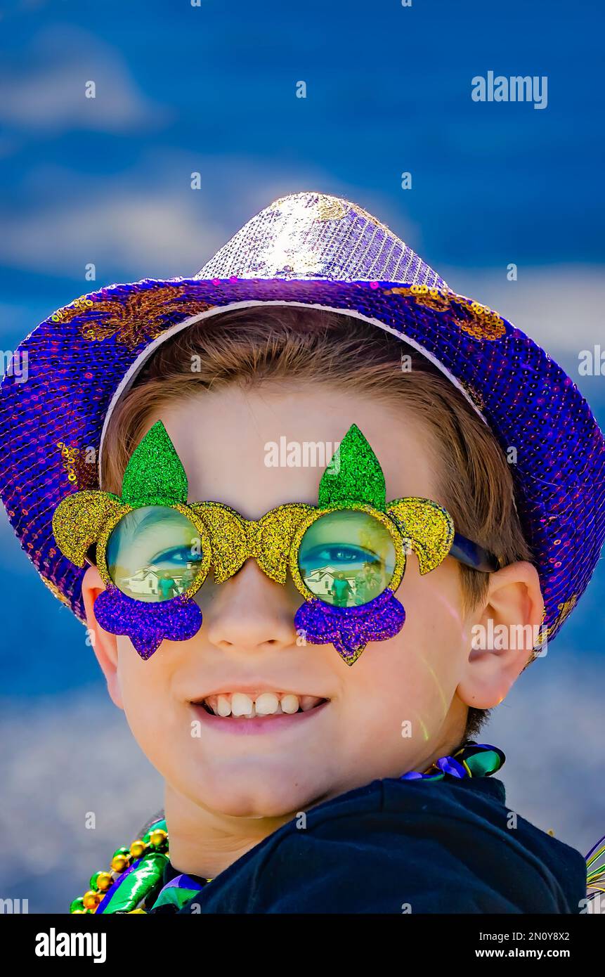 Un enfant regarde à travers les lunettes à gaz de Mardi pendant qu'il se déplace dans le défilé Mystic Krewe de Salty Paws Mardi gras, 4 février 2023, à Dauphin Island, Alabama. Banque D'Images