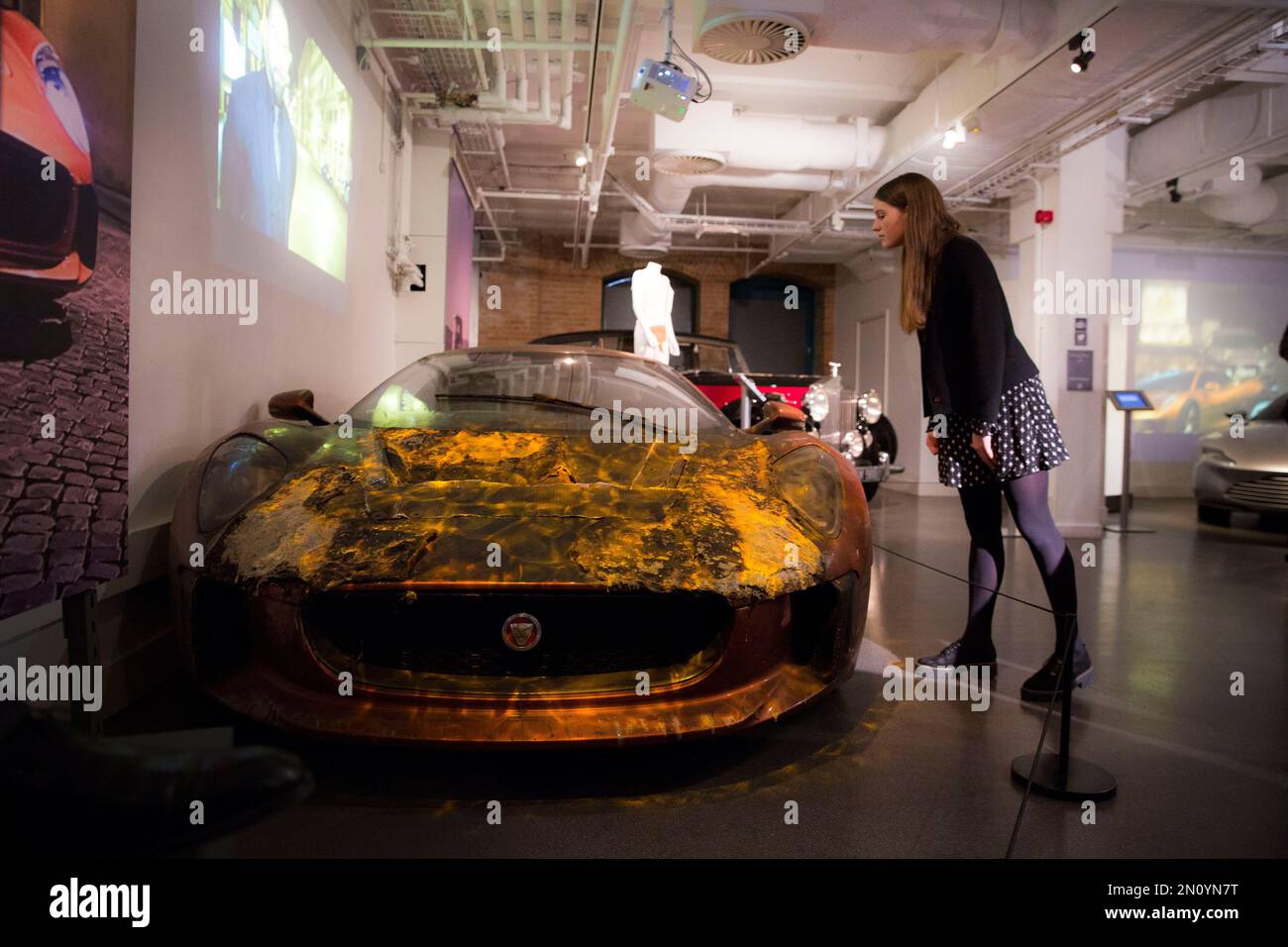 CAPTION CORRECTS THE DAY - A James Bond enthusiast looks at the burnt Jaguar C-X75, as the vehicles used in the filming of new Bond film Spectre join the largest collection of 007 vehicles in the world, at the London Film Museum, London, Tuesday, Nov. 17, 2015. (Photo by Joel Ryan/Invision/AP) Banque D'Images