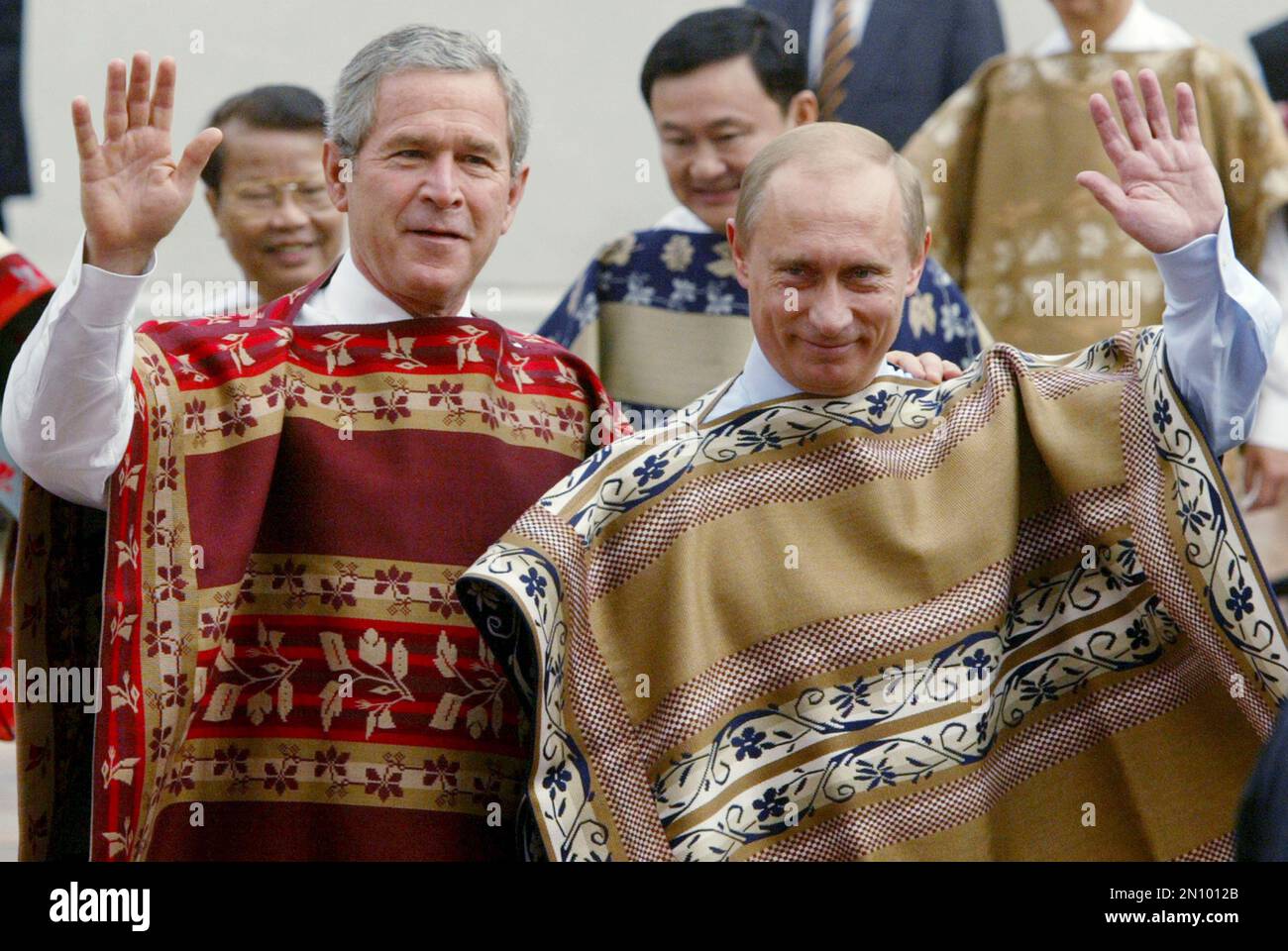 In this Nov. 21, 2004, file photo, U.S. President George W. Bush, left, and Russian President Vladimir Putin wave to photographers prior to the leaders' group photo at the APEC summit in Santiago, Chile. Asia Pacific Economic Cooperation summits, which draw the U.S. president and other heads of state, are sometimes memorable for just one moment: leaders posing for a group photo in unexpected attire. The tradition, started by U.S. President Bill Clinton in 1993 when he handed out leather bomber jackets similar to those worn by American fighter pilots, was apparently to let his fellow VIPs feel Banque D'Images