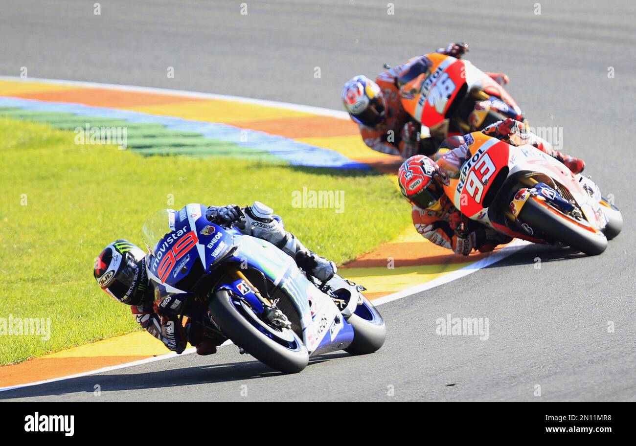 MotoGP rider Jorge Lorenzo of Spain leads the race followed by Marc Marquez, center, and Dani Pedrosa, during the Valencia Motorcycle Grand Prix, the last race of the season, at the Ricardo Tormo circuit in Cheste near Valencia, Spain, Sunday, Nov. 8, 2015. (AP Photo/Alberto Saiz) Banque D'Images
