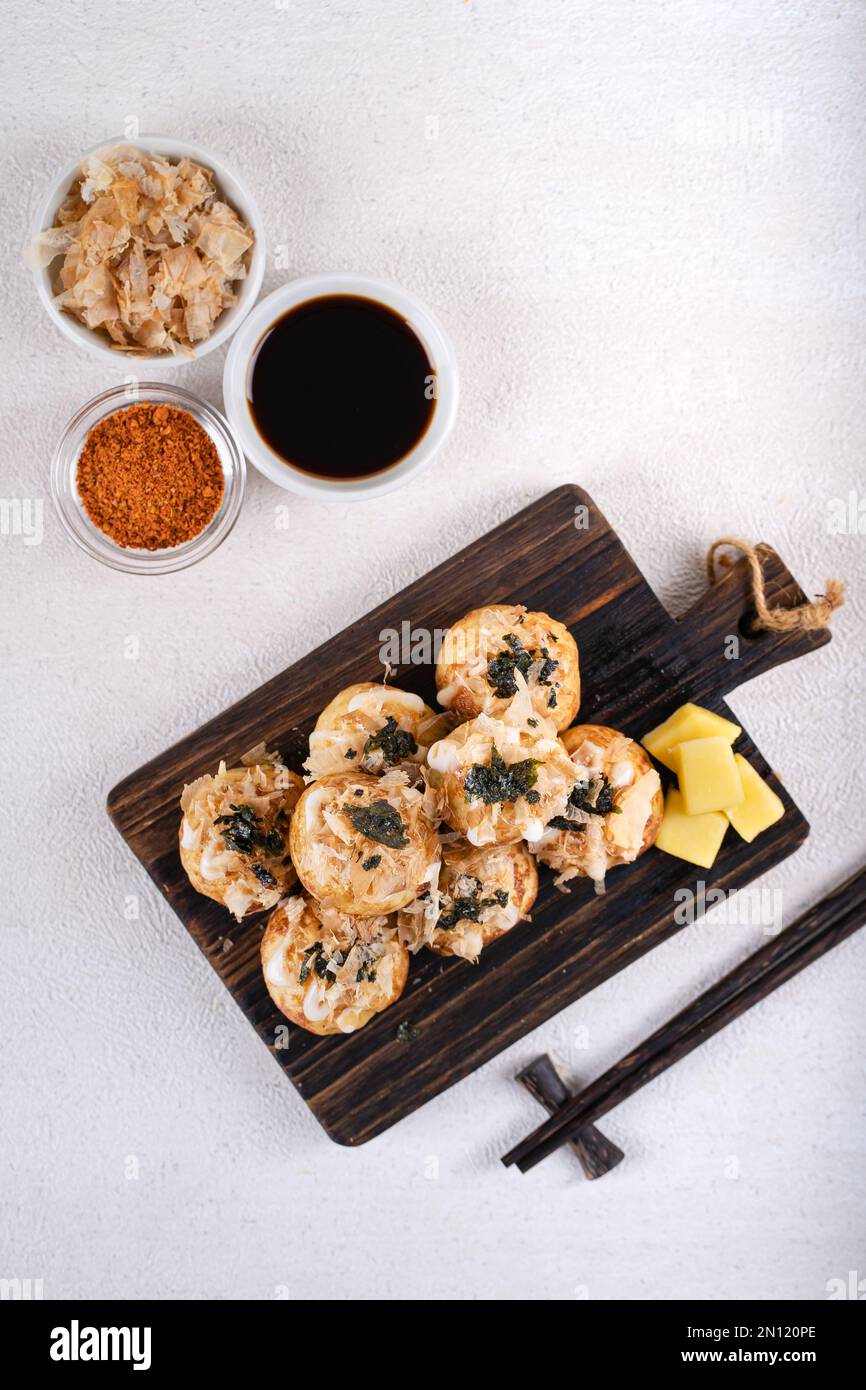 Le takoyaki est une cuisine de rue japonaise contenant du pieuvre, de la saucisse ou du fromage. garnir d'algues et de katsuobushi Banque D'Images
