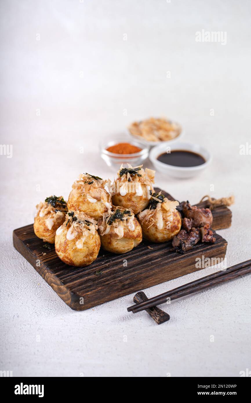 Le takoyaki est une cuisine de rue japonaise contenant du pieuvre, de la saucisse ou du fromage. garnir d'algues et de katsuobushi Banque D'Images