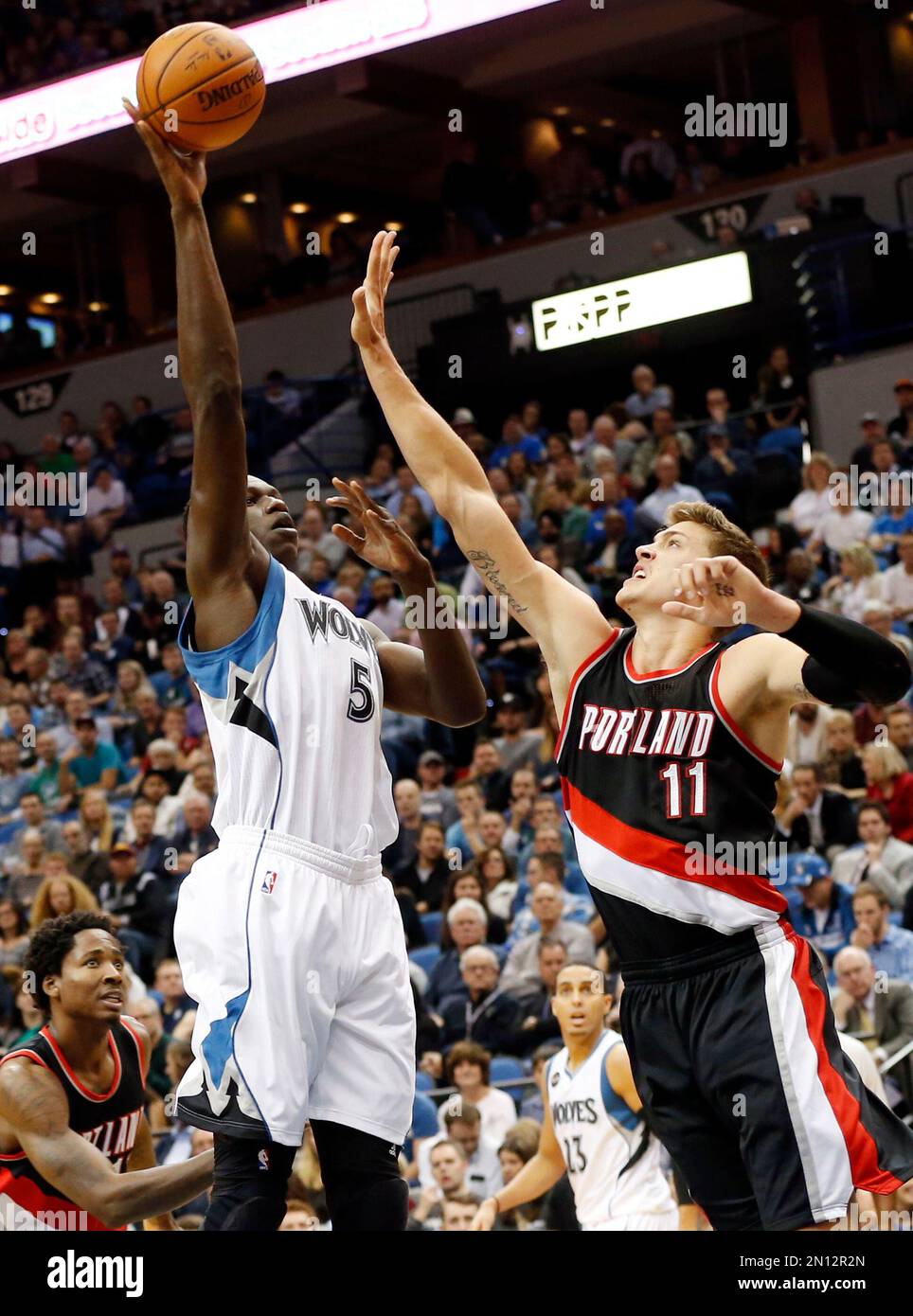 Minnesota Timberwolves’ Gorgui Dieng, left, shoots over Portland Trail Blazers’ Meyers Leonard in the first half of an NBA basketball game Monday, Nov. 2, 2015, in Minneapolis. (AP Photo/Jim Mone) Banque D'Images