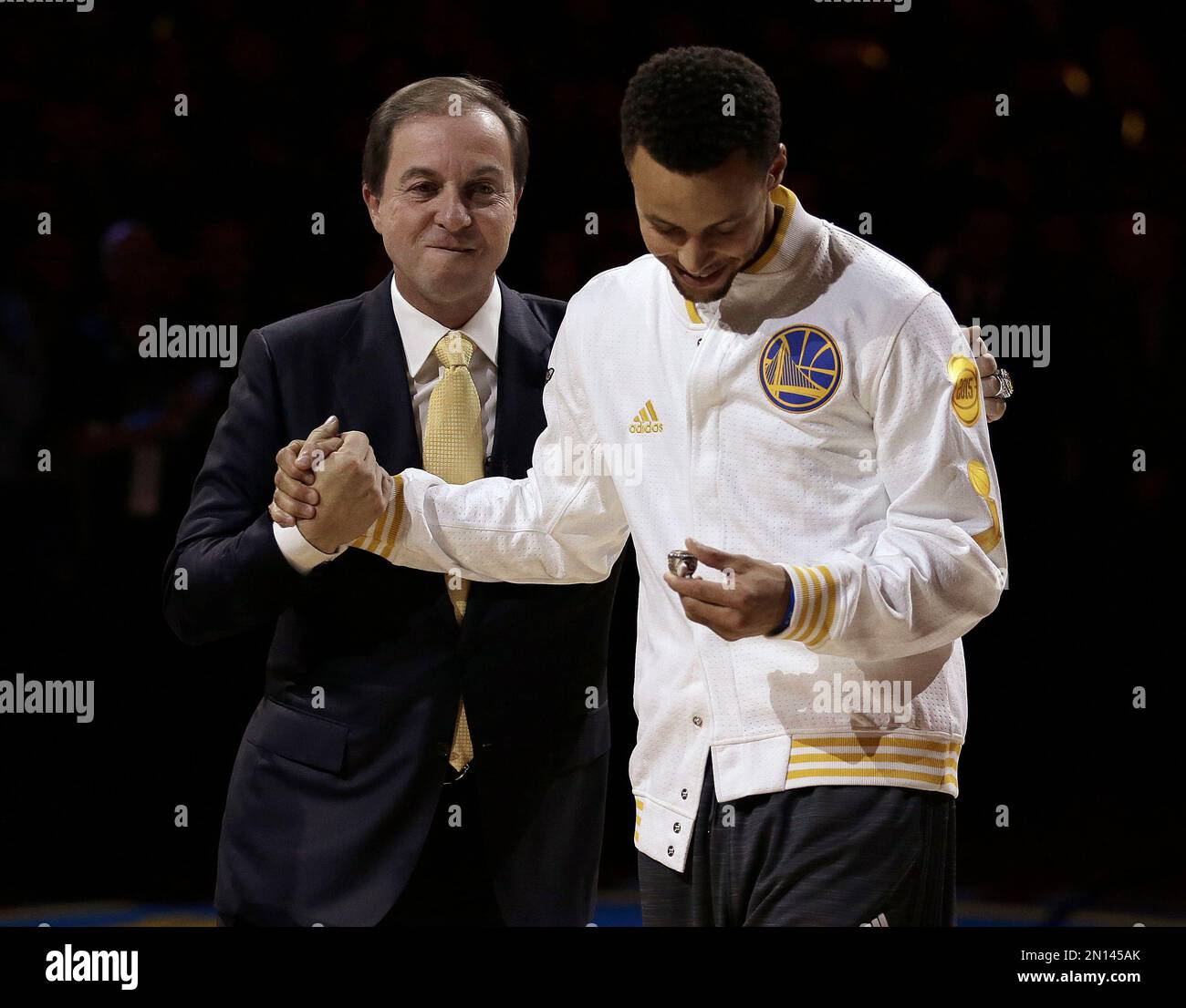 Golden State Warriors' Stephen Curry, right, receives his championship ring from co owner Joe Lacob during an awards ceremony to recognize the Warriors' NBA championship prior to the basketball game against the New Orleans Pelicans Tuesday, Oct. 27, 2015, in Oakland, Calif. (AP Photo/Ben Margot) Banque D'Images