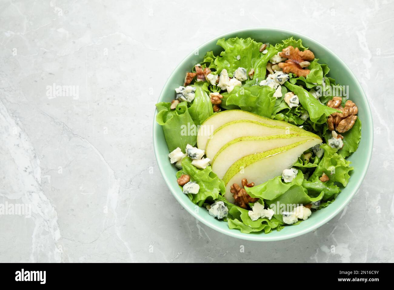 Salade savoureuse avec des tranches de poire sur une table en marbre gris clair, vue du dessus. Espace pour le texte Banque D'Images
