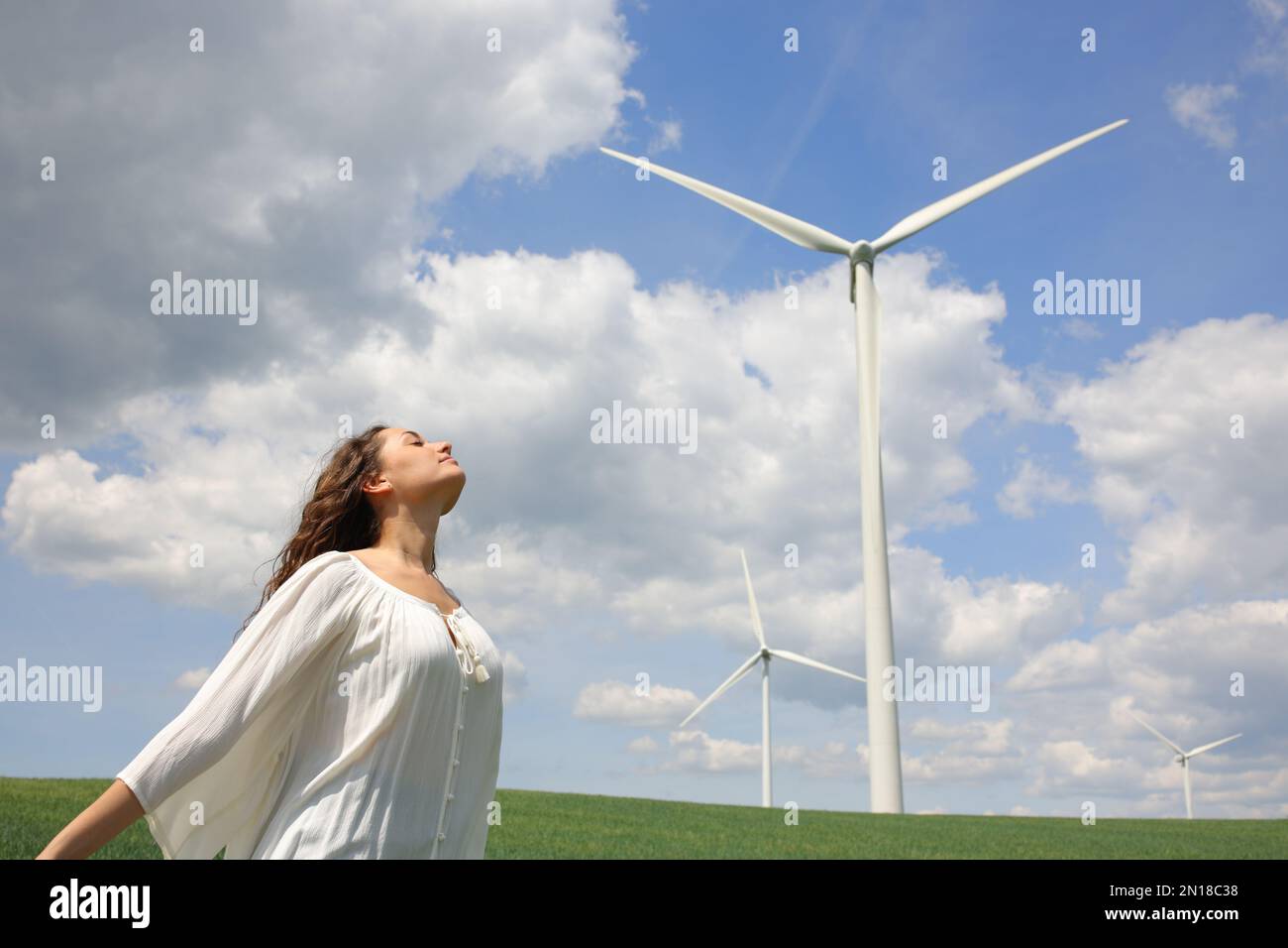 Femme respirant de l'air frais près d'un parc éolien Banque D'Images