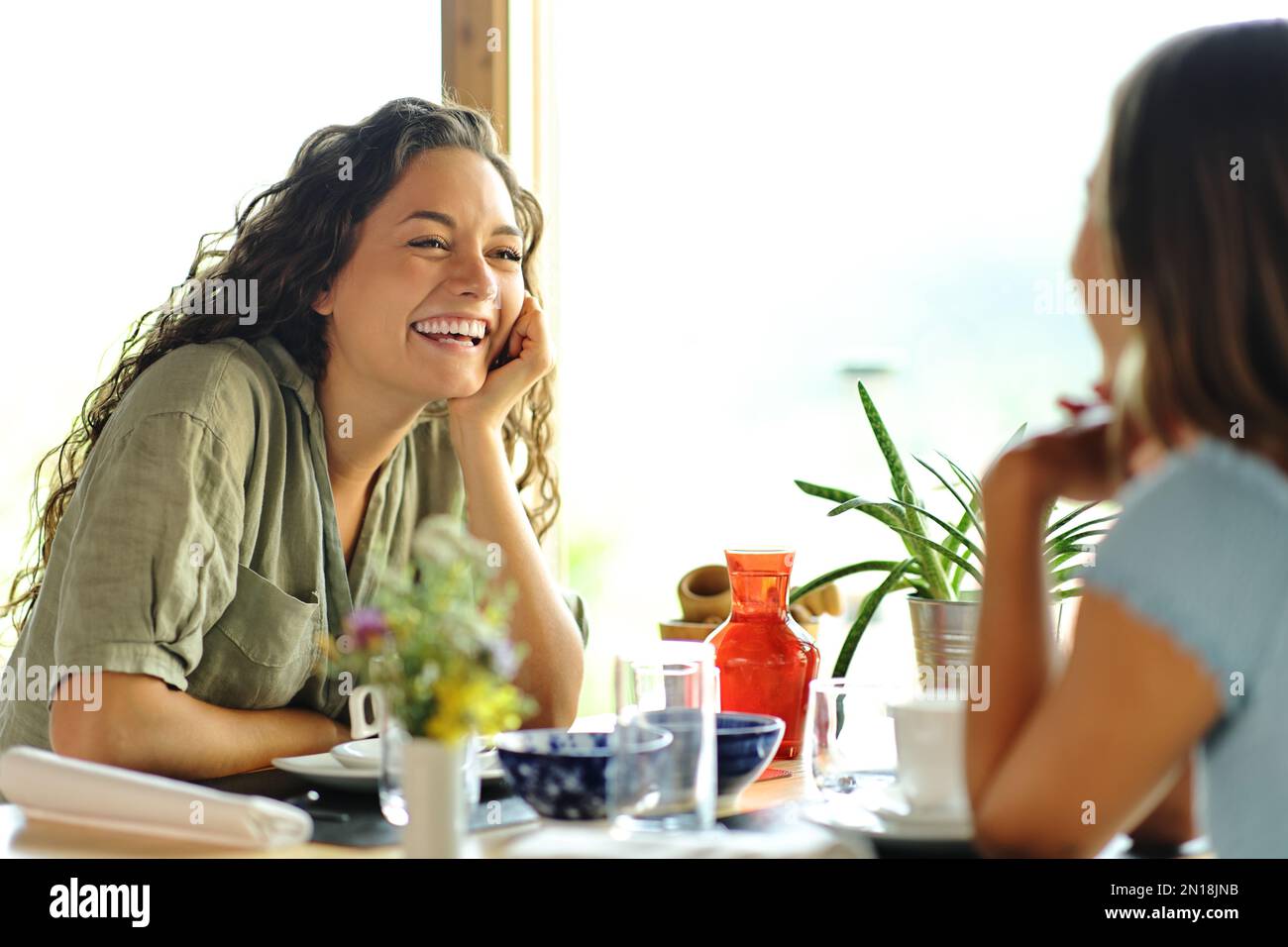 Deux amis heureux parlant dans un restaurant Banque D'Images