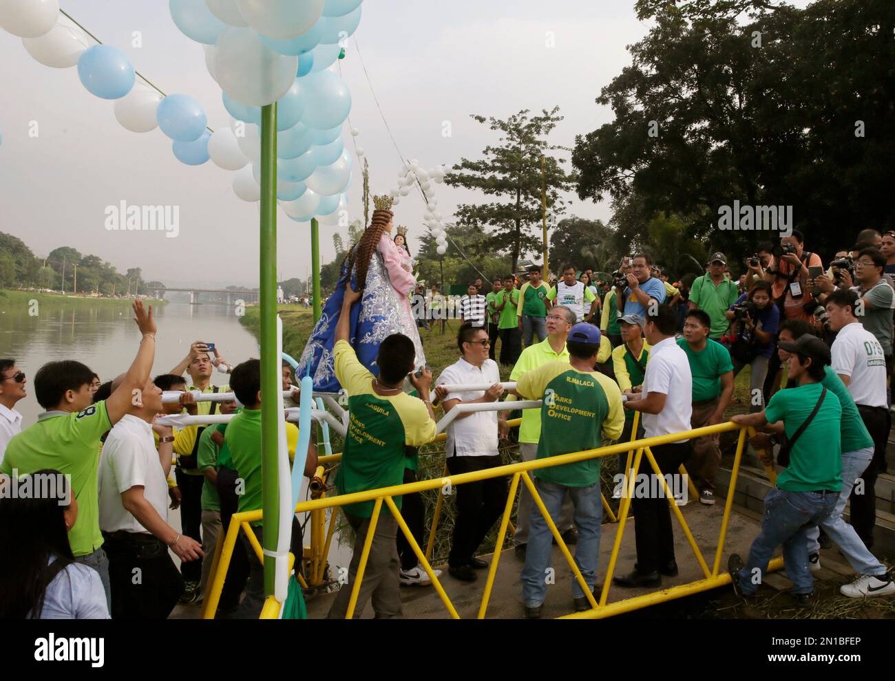 Local government officials and residents carry the religious image of