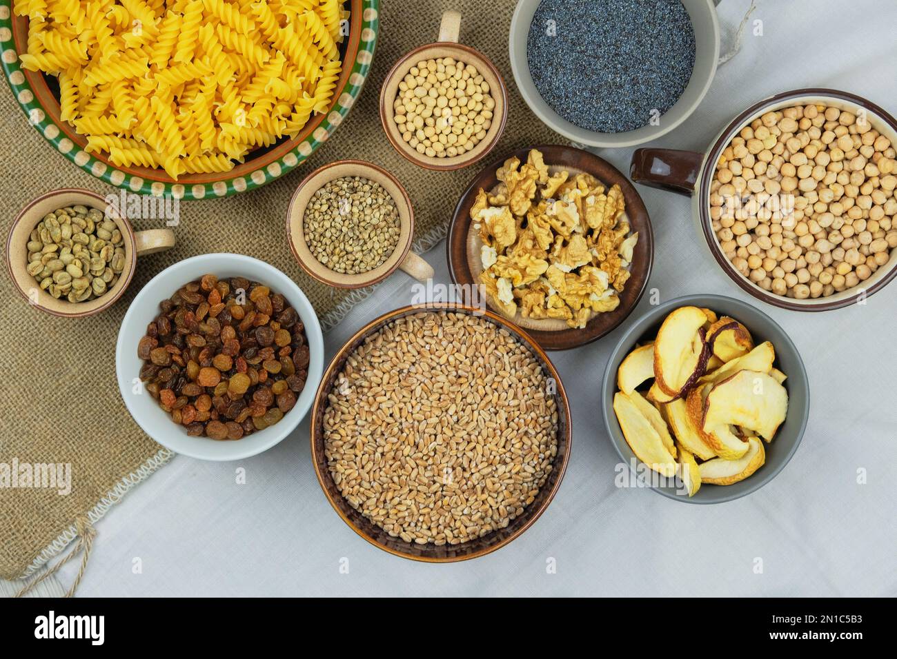 Divers aliments biologiques végétariens dans des bols. Blé, graines de pavot, soja, raisins secs, noix, café, pâtes. Vue de dessus. Banque D'Images Divers aliments biologiques végétariens dans des bols. Blé, graines de pavot, soja, raisins secs, noix, café, pâtes. Vue de dessus. Banque D'Images