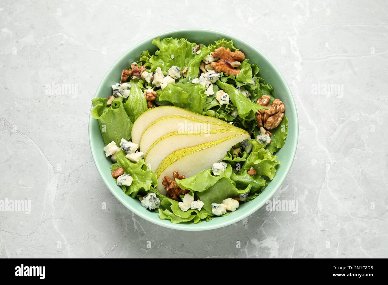 Salade savoureuse avec des tranches de poire sur une table en marbre gris clair, vue du dessus Banque D'Images