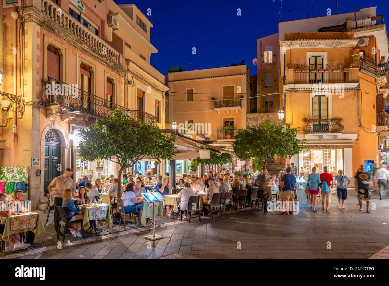 Vue sur les cafés et restaurants dans la rue animée de Taormina au crépuscule, Taormina, Sicile, Italie, Méditerranée, Europe Banque D'Images