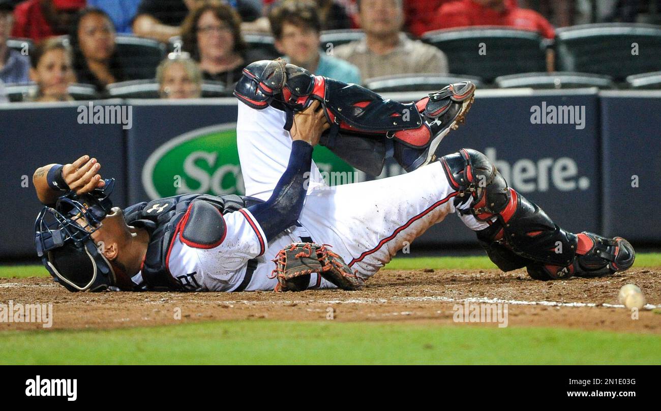 Atlanta Braves catcher Christian Bethancourt reacts after a collision in which Philadelphia Phillies' Chase d'Arnaud was out at home plate during the seventh inning of a baseball game Friday, Sept. 18, 2015, in Atlanta. (AP Photo/John Amis) Banque D'Images