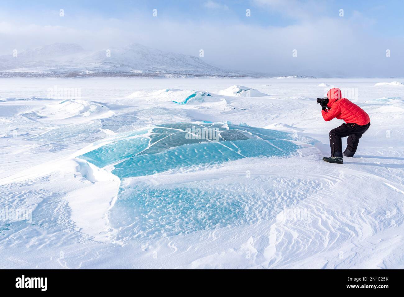 Homme photographiant le paysage arctique recouvert de neige sur un lac gelé, Comté de Norrbotten, Laponie, Suède, Scandinavie, Europe Banque D'Images