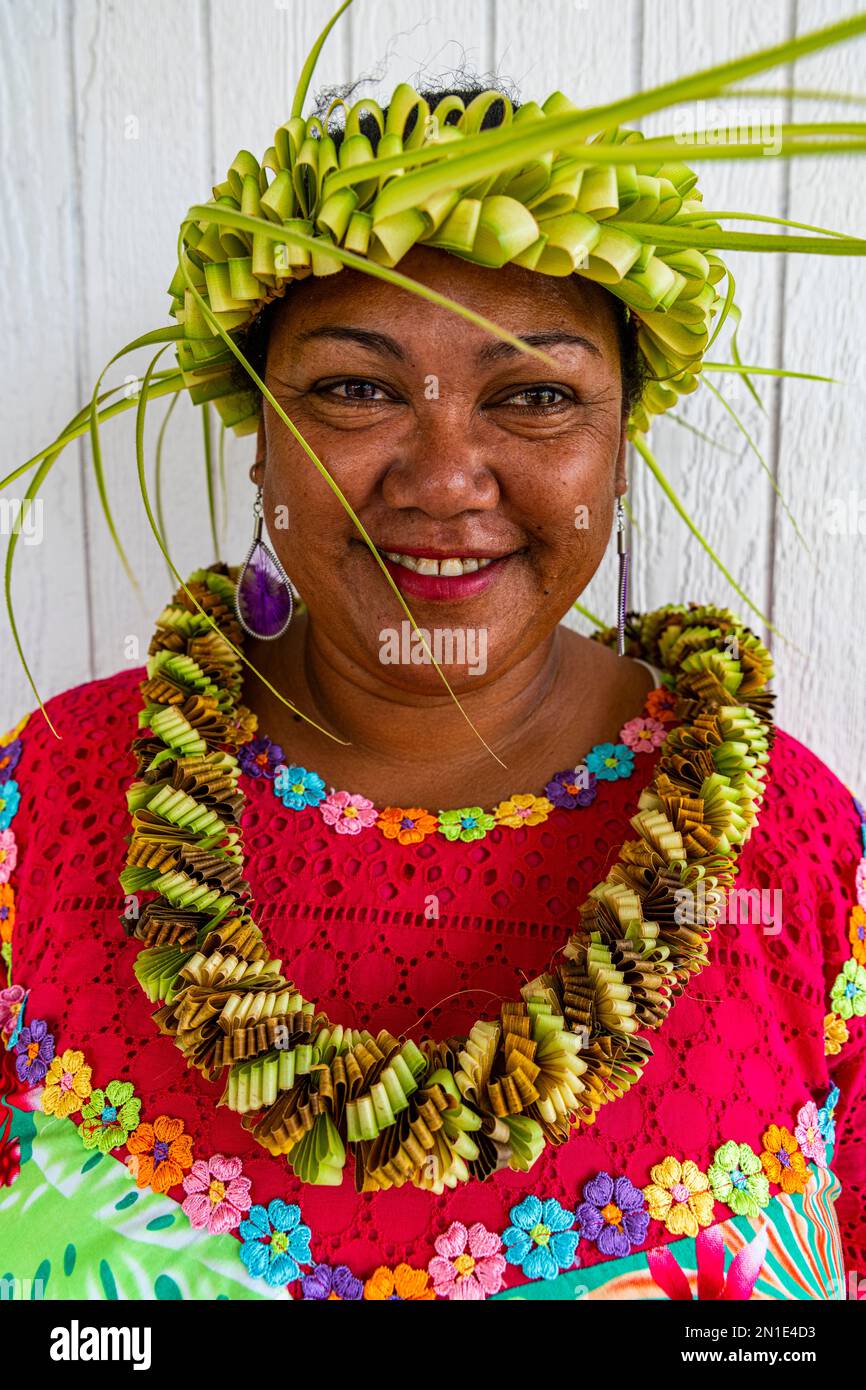 Femme vêtue colorée avec bande de feuilles tissée sur sa tête, Hikueru, archipel de Tuamotu, Polynésie française, Pacifique Sud, Pacifique Banque D'Images
