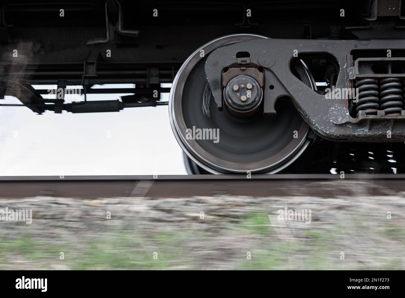 Les roues et le bogie du train de marchandises se déplacent rapidement le long du chemin de fer. Banque D'Images