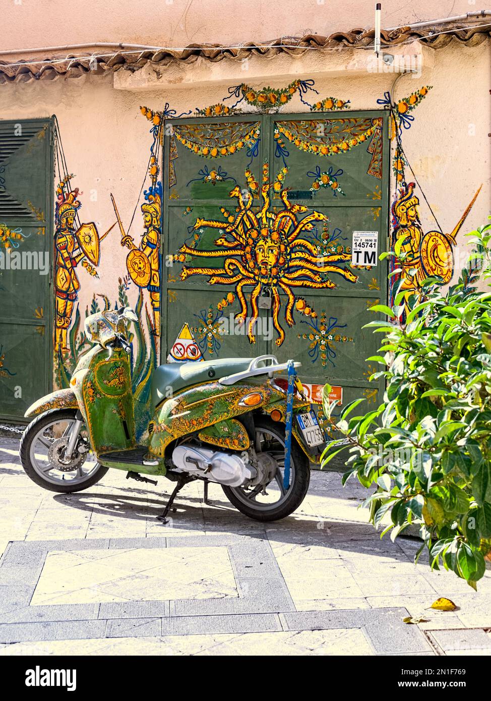Moto verte et jaune aux couleurs vives dans la vieille ville de Taormina Sicile Italie Banque D'Images