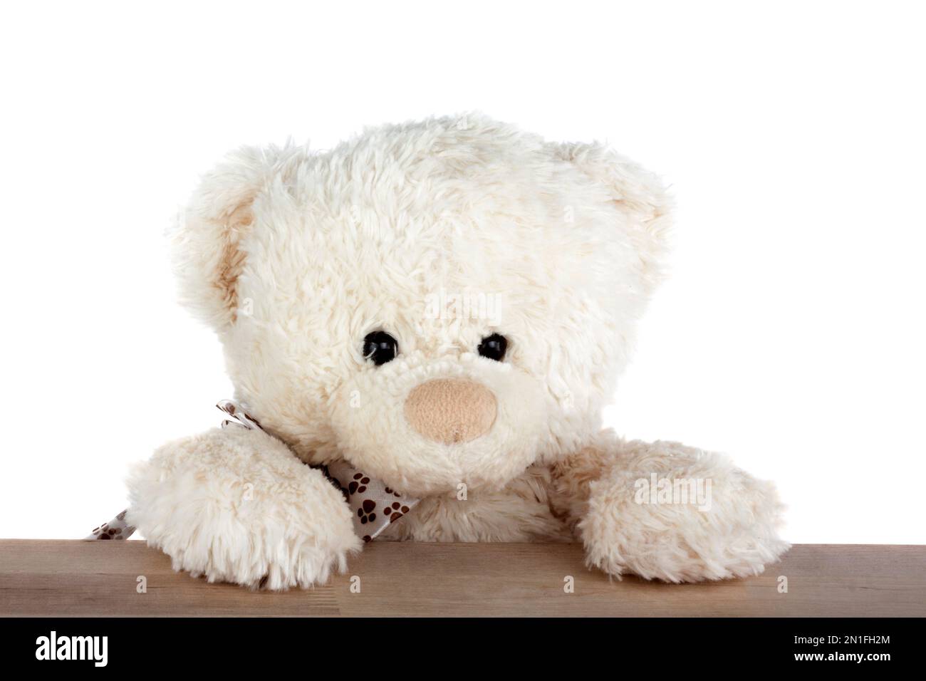 Teddy Bear assis au bureau en bois isolé sur fond blanc Banque D'Images