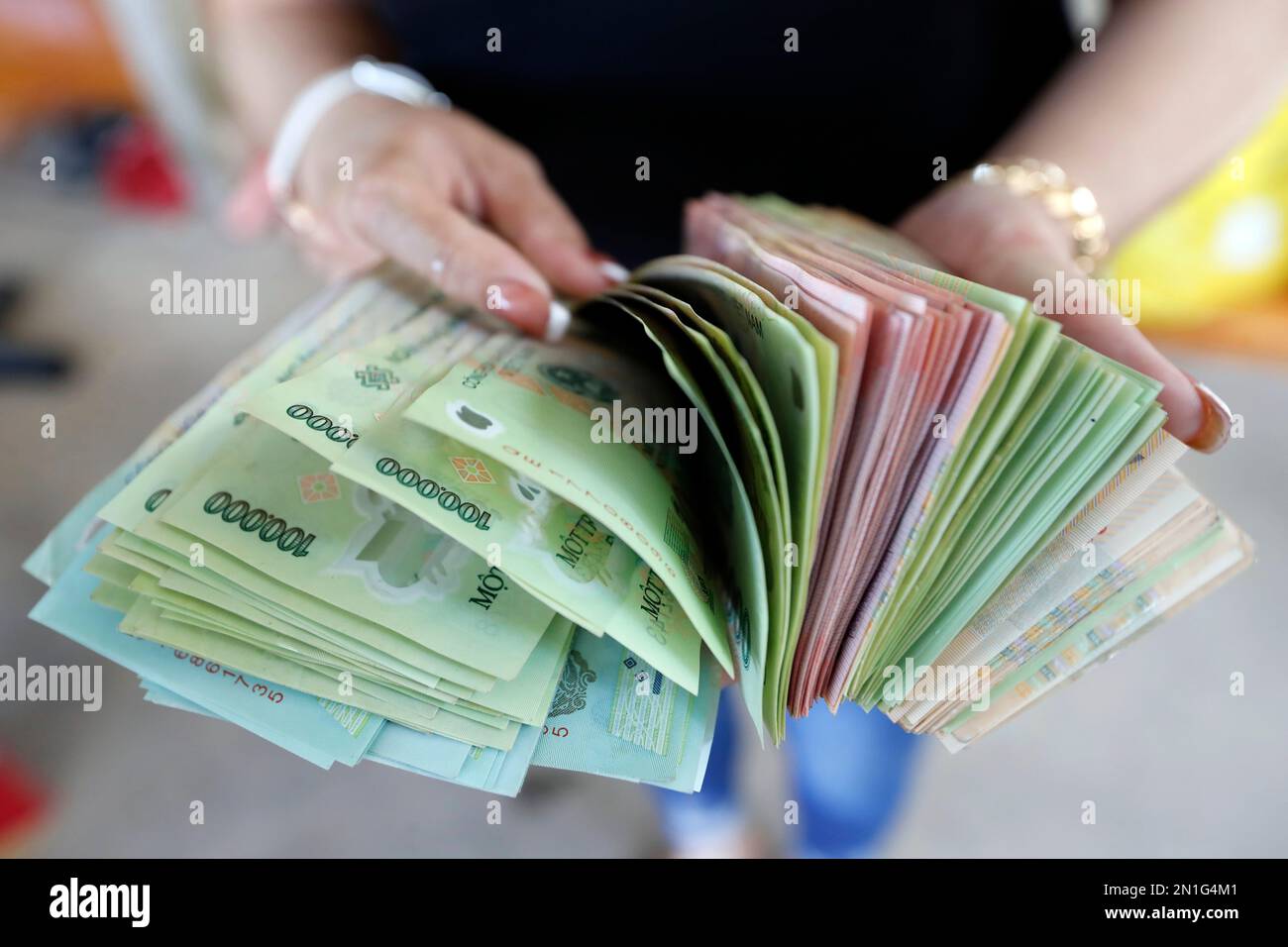 Monnaie vietnamienne, le Dong, billets de banque détenus par la femme, concept d'économie, Vietnam, Indochine, Asie du Sud-est, Asie Banque D'Images