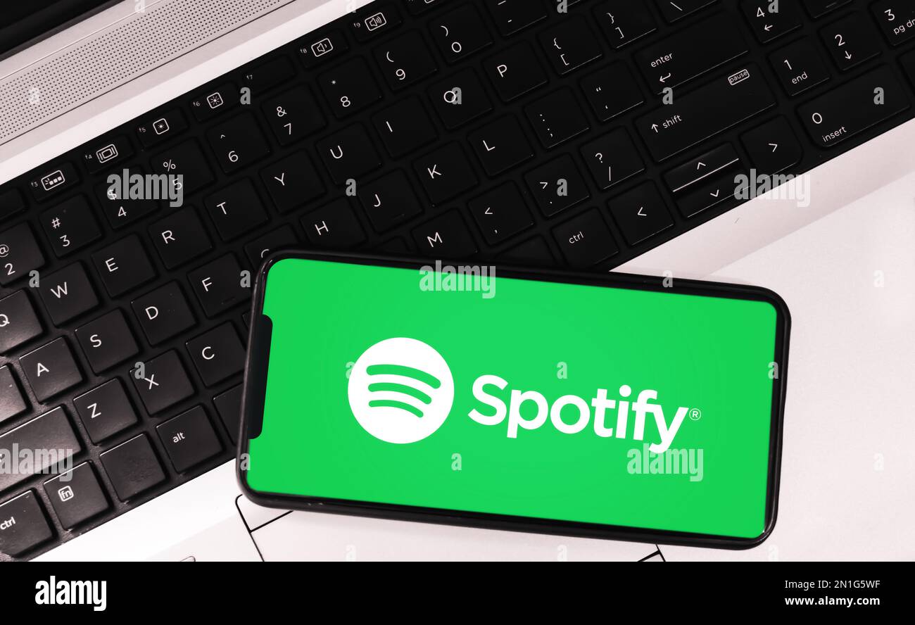 Application moderne de diffusion de musique audio spotify sur écran mobile avec ordinateur portable en toile de fond, éditorial Banque D'Images