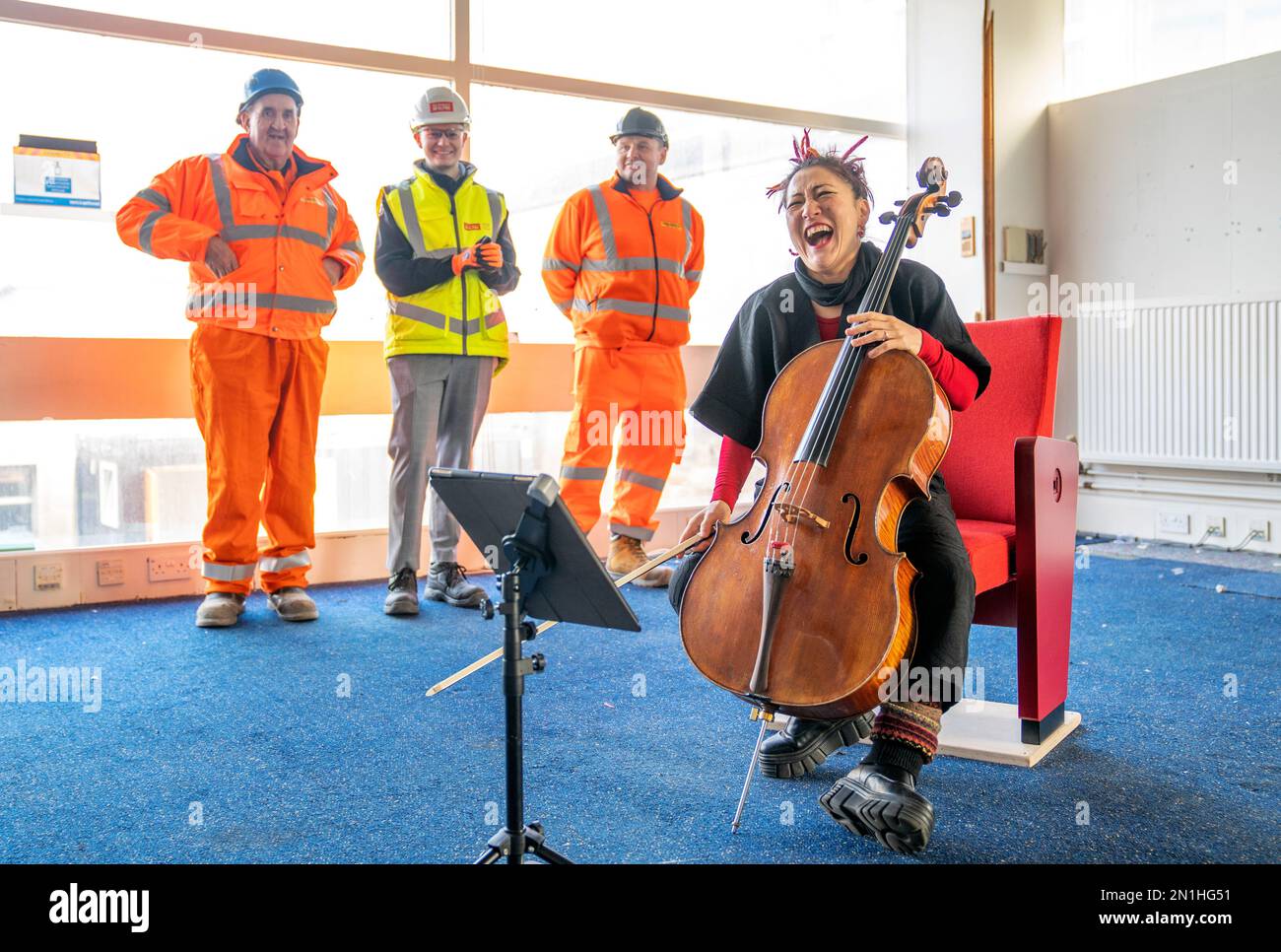 Su-a Lee, le principal violoncelliste du Scottish Chamber Orchestra, joue auprès d'un public de travailleurs de la construction lors d'une conférence de presse marquant le premier jour de travail pour nettoyer le site près de St Andrew Square, à Édimbourg, en amont de la construction du Dunard Centre, la nouvelle salle de concert de classe mondiale de la ville. Date de la photo: Lundi 6 février 2023. Banque D'Images