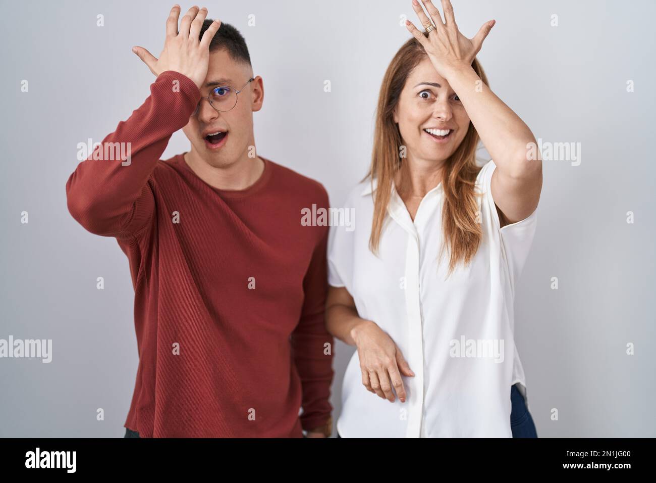 Mère et fils se tenant ensemble sur un fond isolé surpris de main sur la tête pour erreur, se souvenir de l'erreur. oubli, mauvais concept de mémoire. Banque D'Images Mère et fils se tenant ensemble sur un fond isolé surpris de main sur la tête pour erreur, se souvenir de l'erreur. oubli, mauvais concept de mémoire. Banque D'Images