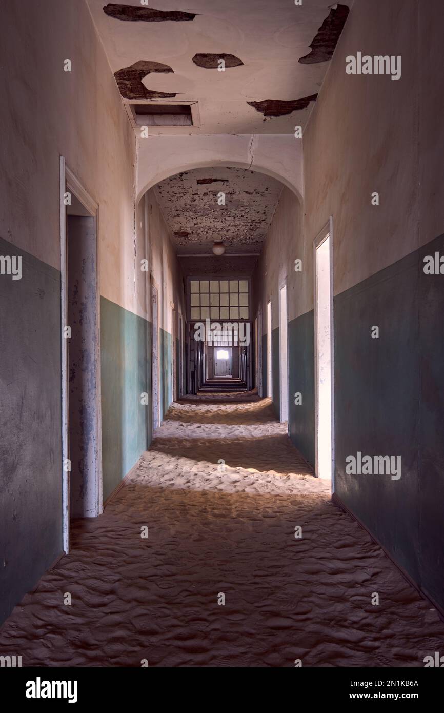 Vide, couloir rempli de sable dans l'hôpital de la ville fantôme de Kolmanskop, Namibie. Image photo créative améliorée. Banque D'Images