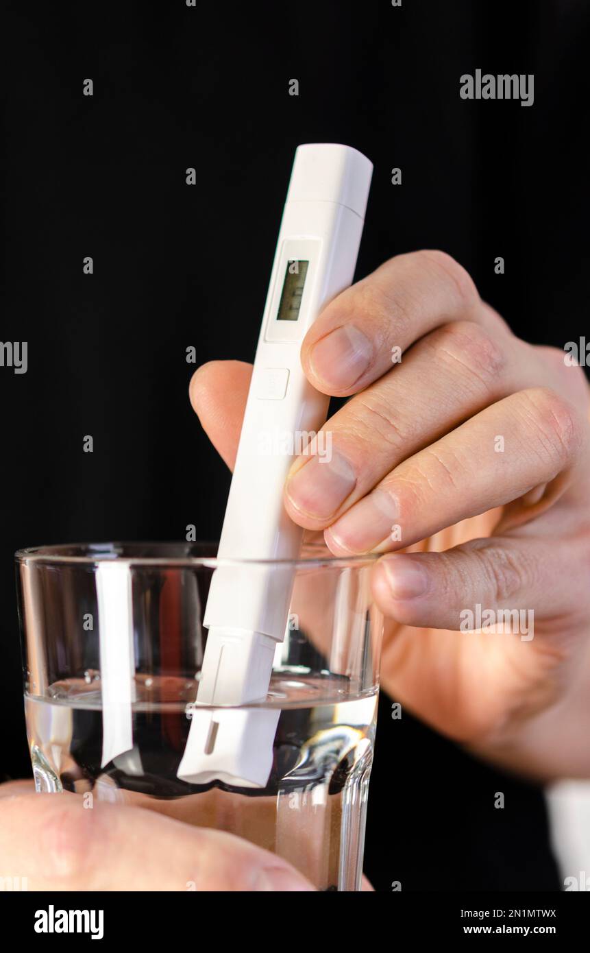 Testeur de qualité de l'eau dans un verre d'eau. Mesure de la qualité de l'eau potable. Banque D'Images