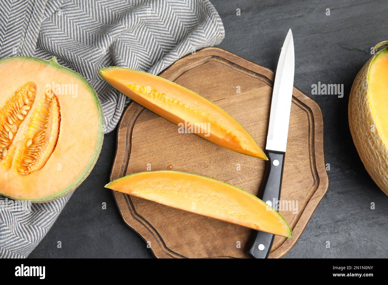 Délicieux melons frais sur table noire, plat Banque D'Images