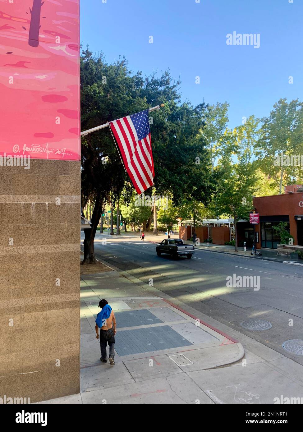 Homme sans-abri / VagGrant dans la rue à Sacramento, CA. Debout sous le drapeau des États-Unis Banque D'Images