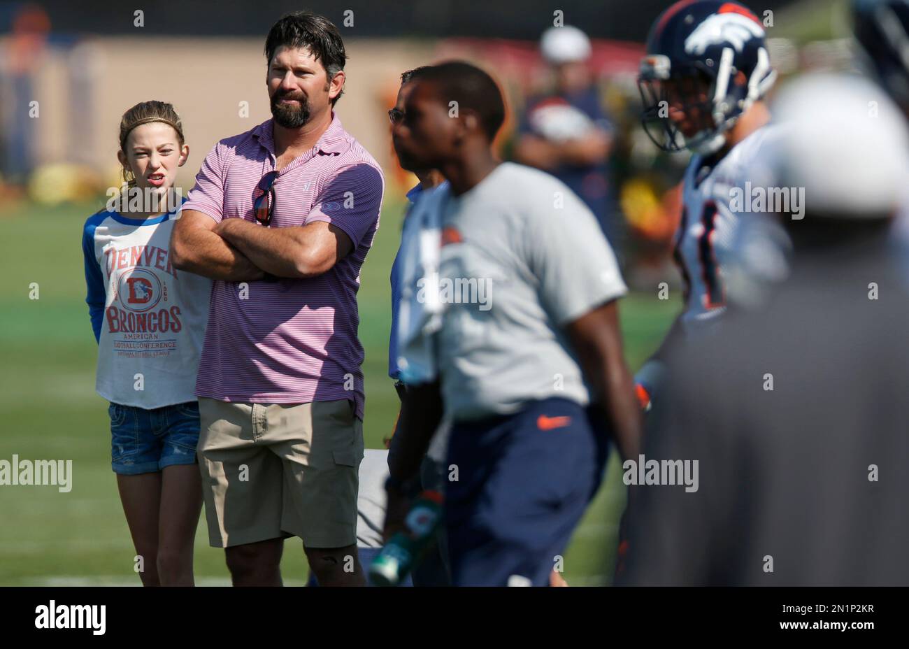 Retired Colorado Rockies first baseman Todd Helton, second from left, looks on with his daughter, Tierney Faith, at the Denver Broncos morning session of the team's NFL football training camp Tuesday, Aug. 18, 2015, in Englewood, Colo. (AP Photo/David Zalubowski) Banque D'Images