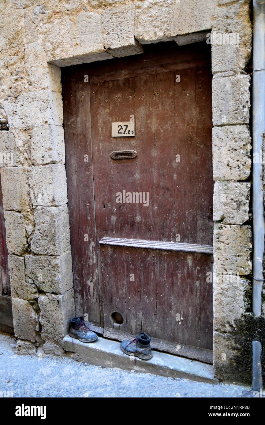 Ancienne porte d'entrée avec une paire de bottes sur la marche Condom dans le département du Lot-et-Garonne, sud-ouest de la France Banque D'Images