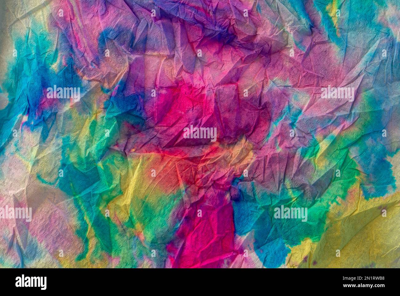 Texture créée avec du papier de serviette et des aquarelles liquides multicolores créant un effet dégradé et arc-en-ciel Banque D'Images