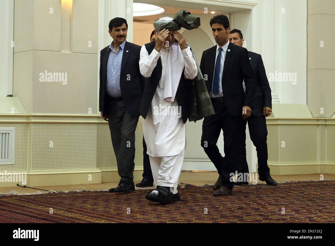 Afghanistan's President Ashraf Ghani, center, arrives for a press conference at the presidential palace in Kabul, Afghanistan, Sunday, July 12, 2015. Ghani talked about a two-day summit he just attended in Russia. (AP Photo/Massoud Hossaini) Banque D'Images