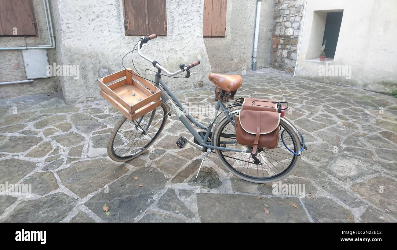 Vélo rétro moderne avec caisse en bois et sacs en cuir sur la roue arrière dans la vieille ville Banque D'Images