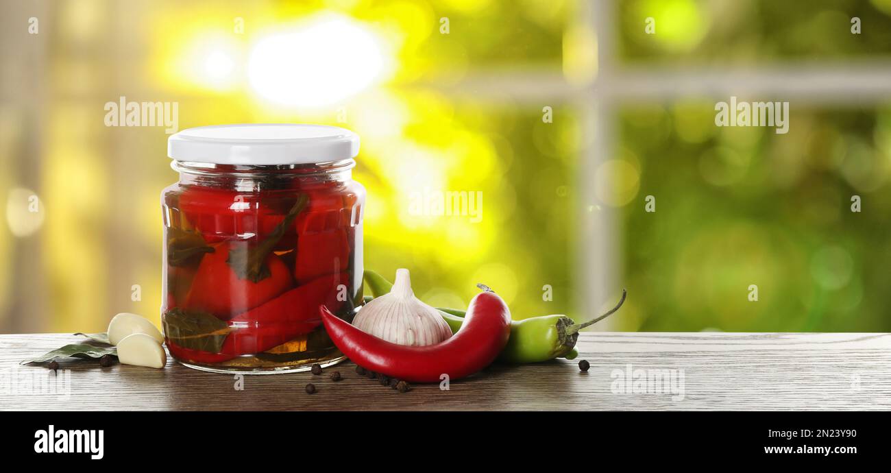 Pot de savoureux piments piquants sur table en bois dans la cuisine, espace pour le texte. Bannière Banque D'Images