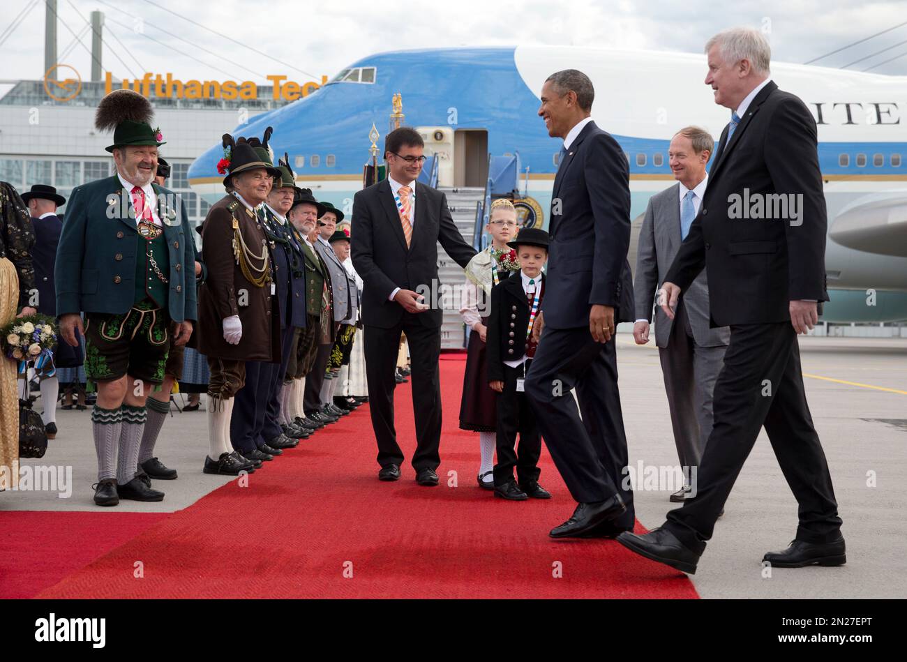 US President Barack Obama, joined by Horst Seehofer, Minister President of Bavaria, right, and US Ambassador to Germany John B. Emerson, second from right, is greeted by traditionally dressed Bavarian men and women as he arrives on Air Force One at the airport in Munich, southern Germany, Sunday, June 7, 2015, en route to the G-7 summit at the Schloss Elmau hotel near Garmisch-Partenkirchen, southern Germany. (AP Photo/Carolyn Kaster) Banque D'Images