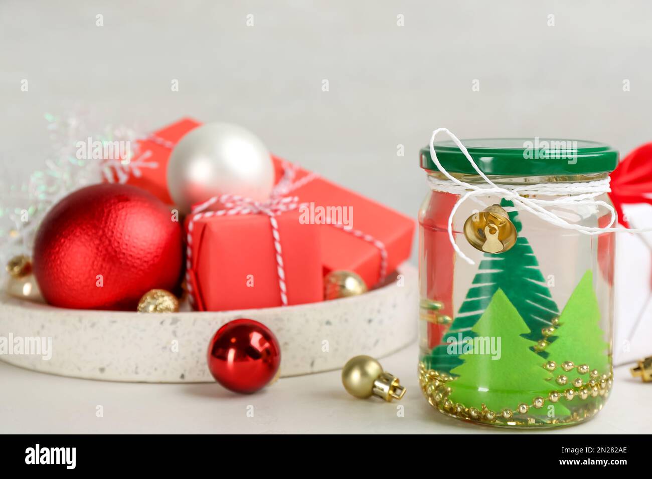 Boule à neige artisanale et décorations de Noël sur table lumineuse Photo  Stock - Alamy
