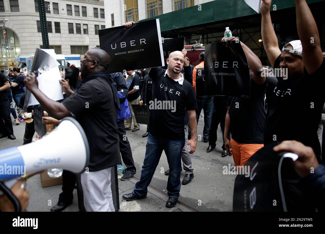 Uber drivers and their supporters protest in front of the offices of the Taxi and Limousine Commission in New York, Thursday, May 28, 2015. Uber and Lyft are pushing back against a New York City effort to regulate app-based car services. The proposal before the Taxi and Limousine Commission would require car services that riders can summon with their phones to comply with many of the rules that govern the yellow cabs they compete with. (AP Photo/Seth Wenig) Banque D'Images
