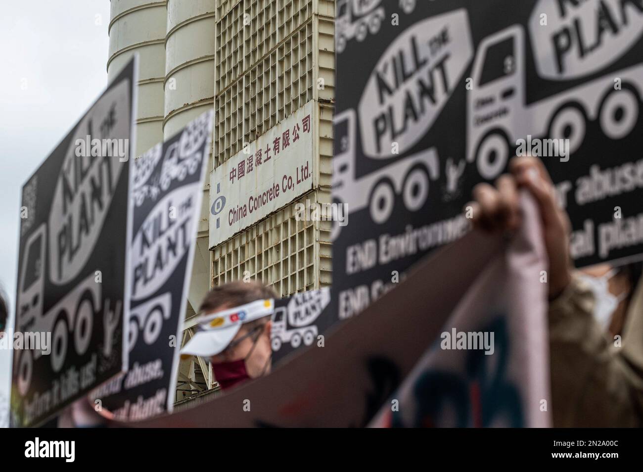 Hong Kong, Chine. 04th févr. 2023. L'usine China Concrete Company, vue à travers des plaques de protestation. Un groupe de militants des droits de l'environnement et du travail a convergé pour protester contre l'inaction du gouvernement à propos de la fermeture de la cimenterie polluante qui a des antécédents de violations et n'a pas de permis d'exploitation. Il s'agissait de l'une des premières manifestations approuvées depuis que les mesures de distanciation sociale de la COVID-19 ont été assouplies à Hong Kong et pourraient marquer le retour des mouvements sociaux actifs de la ville. Crédit : SOPA Images Limited/Alamy Live News Banque D'Images