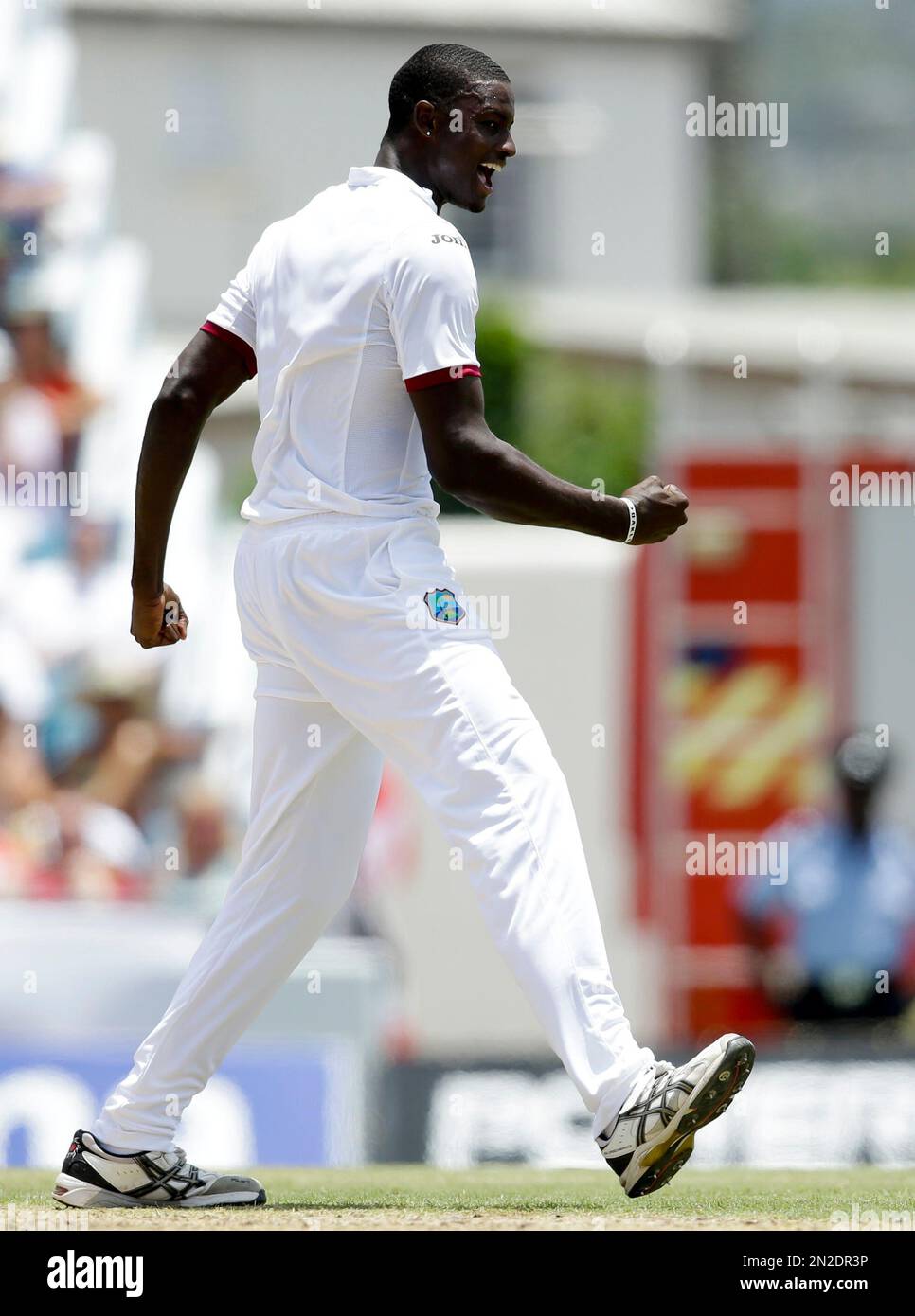 West Indies' bowler Jason Holder, left, celebrates after he caught England's Jos Buttler during day one of their third Test match at the Kensington Oval in Bridgetown, Barbados, Friday, May 1, 2015. (AP Photo/Ricardo Mazalan) Banque D'Images