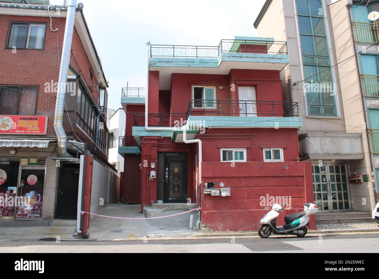 Immeuble de style villa en brique rouge avec scooter blanc devant Banque D'Images