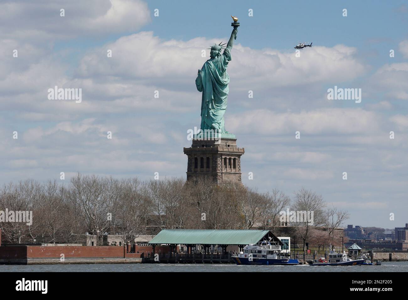 New York Police boats are docked at Liberty Island where the Statue of Liberty was evacuated with officers responding to a report of a suspicious package seen from Jersey City, N.J., Friday, April 24, 2015. Visitors are posting photos online showing hundreds of people being herded toward a ferry landing. Tourists say they were taken off boats while trying to leave nearby Ellis Island. Those vessels then were used to evacuate Liberty Island. (AP Photo/Julio Cortez) Banque D'Images