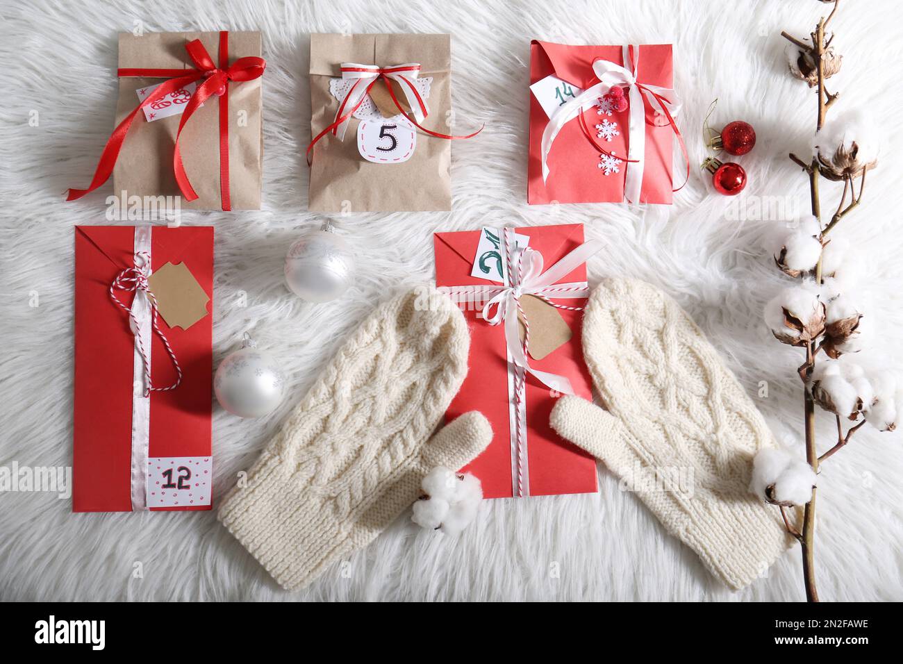 Composition de dessus-de-plat avec cadeaux de Noël, moufles et décor festif  sur un tapis blanc moelleux. Création du calendrier de l'Avent Photo Stock  - Alamy