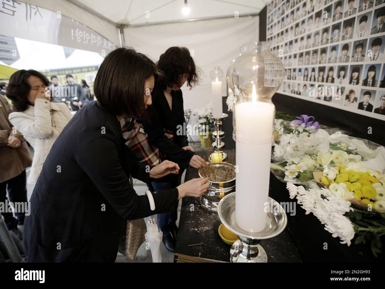 Mourners burn incenses to pay tribute to victims of the sunken ferry Sewol at a temporary memorial altar in Seoul, South Korea, Thursday, April 16, 2015. Tears and grief mixed with raw anger Thursday as black-clad relatives mourned the 300 people, mostly high school kids, killed one year ago when the ferry Sewol sank in cold waters off the southwestern South Korean coast. (AP Photo/Ahn Young-joon) Banque D'Images