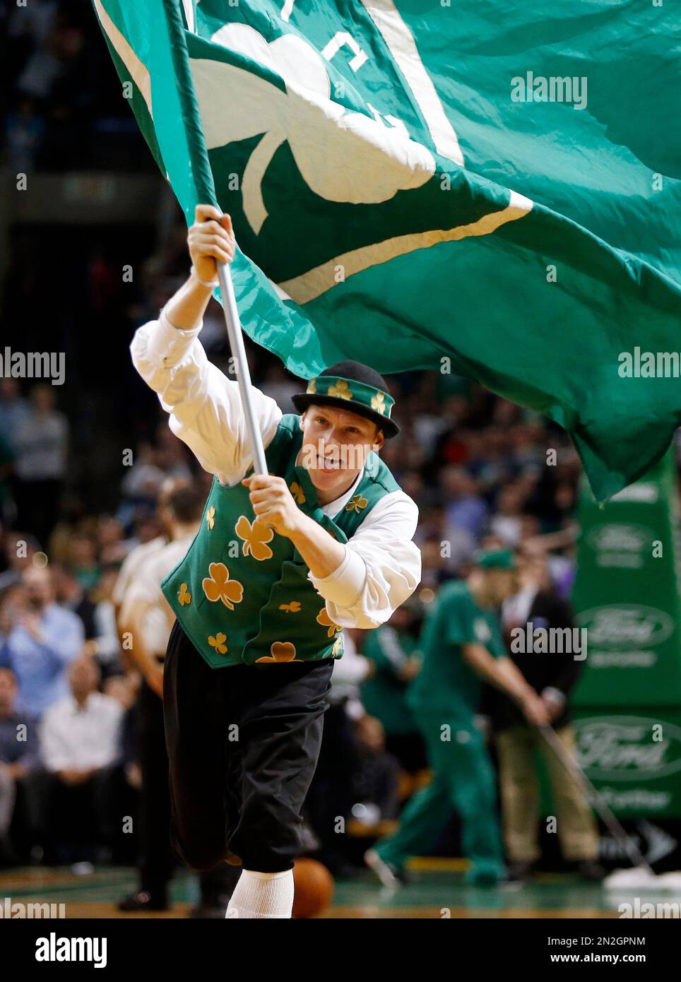The Boston Celtics mascot Lucky runs with a flag during the fourth quarter of an NBA basketball game against the Toronto Raptors in Boston, Tuesday, April 14, 2015. The Celtics won 95-93. (AP Photo/Michael Dwyer) Banque D'Images
