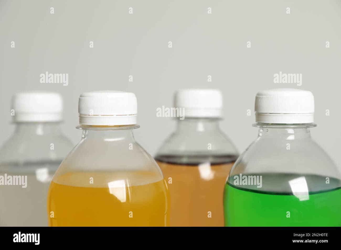 Bouteilles de boissons non alcoolisées sur fond gris, gros plan Banque D'Images