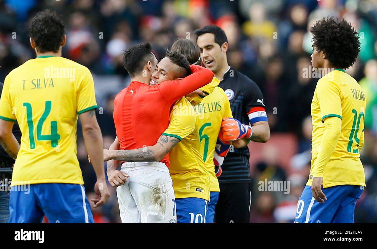 Chile’s Alexis Sanchez, in red, is hugged by Brazil’s Neymar following the end of the international friendly soccer match soccer match between Brazil and Chile at the Emirates stadium in London, Sunday, March 29, 2015. Brazil won the match 1-0. (AP Photo/Kirsty Wigglesworth) Banque D'Images