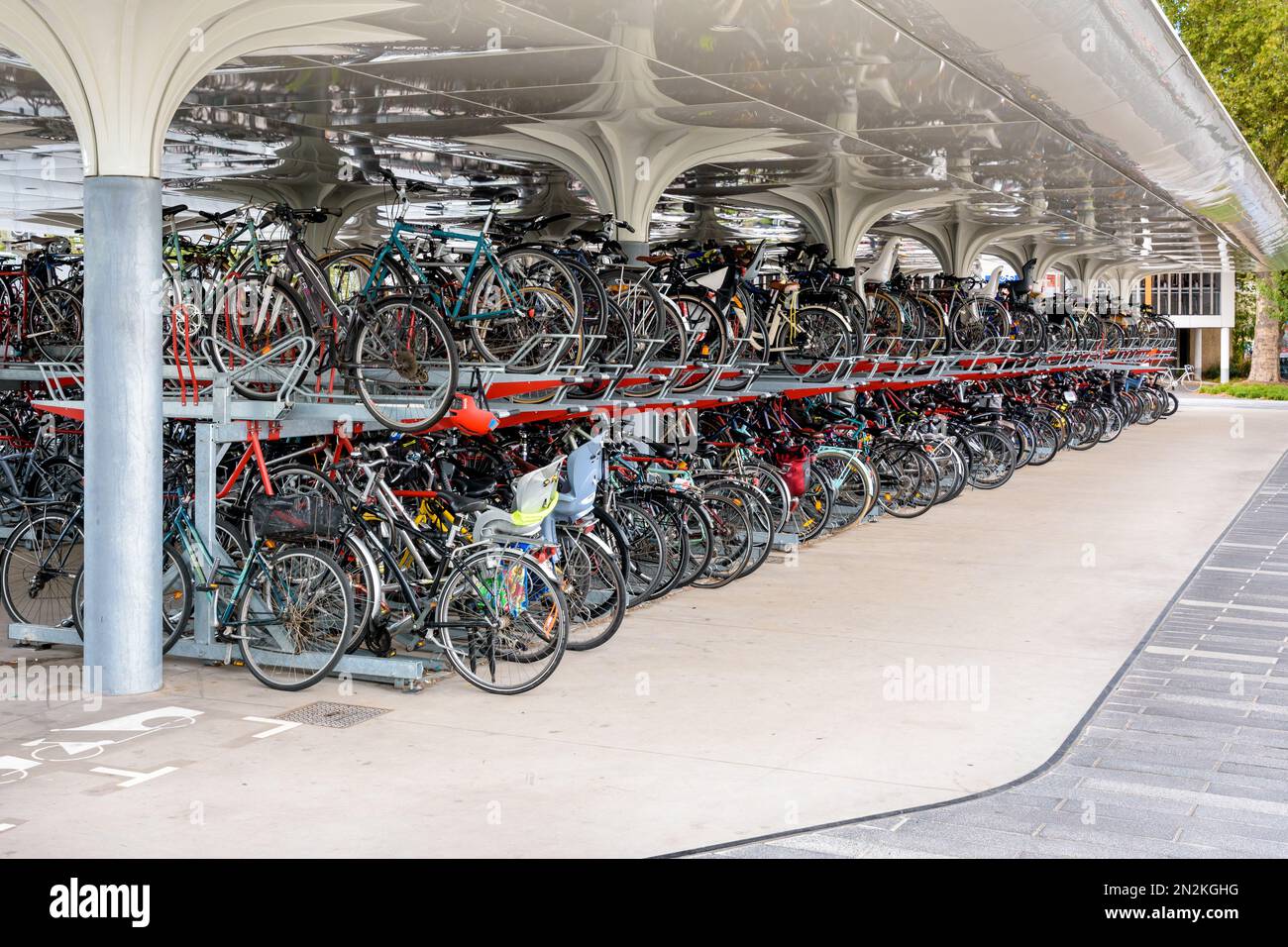 Des centaines de vélos sont garés dans un parking couvert à deux ponts à l'extérieur de la gare de Nantes, en France, pendant la journée. Banque D'Images