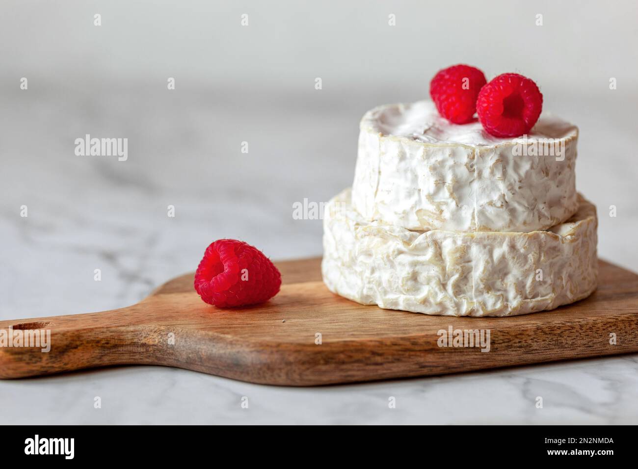 fromage doux français camembert servi avec des framboises, minimalisme Banque D'Images